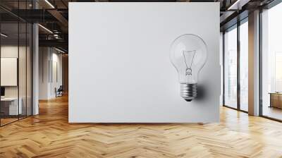 Flat lay of a light bulb with an empty background, leaving the top half of the image open for copy, perfect for energy or home improvement ads. Wall mural