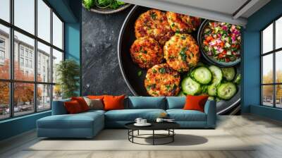 Top view of a dish of Thai fish cakes with a side of cucumber relish. Wall mural