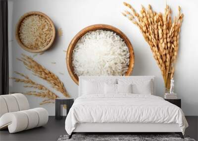 White Jasmine rice in a wooden bowl, accompanied by paddy rice and an ear of rice, top view, isolated on white background. Perfect for traditional food photography. Wall mural