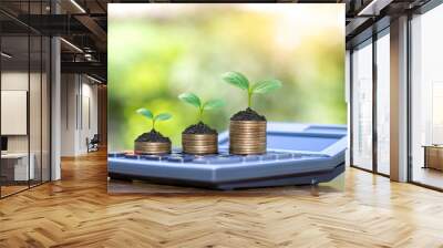 Plant trees on coins and calculators, financial accounting concepts and save money. Wall mural