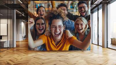 Group of excited young adults celebrating together indoors, showing joy and enthusiasm. Diverse friends enjoying a cheerful moment. Wall mural