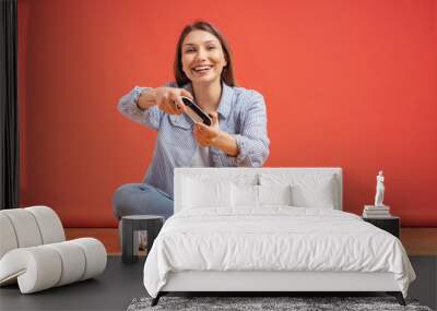 Excited casual young woman playing video games having fun on red background Wall mural