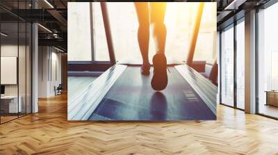 Fitness girl running on treadmill Wall mural