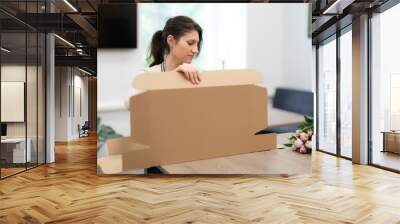 Woman Florist working in her workshop with flowers making a composition box on order Wall mural