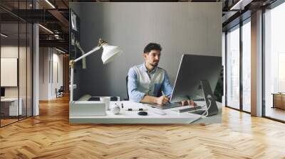 Young graphic designer working in office Wall mural