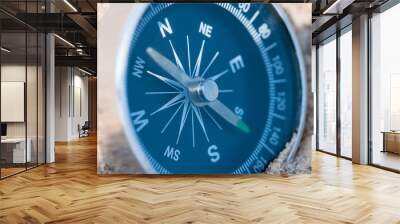 Compass on the sea sand. Close up. Wall mural