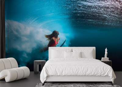 Attractive surfer woman dive underwater with big wave. Wall mural