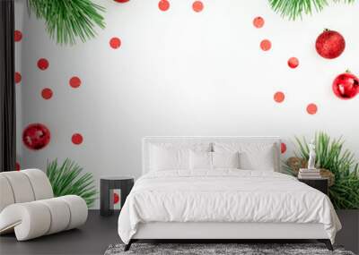 Christmas frame made of pine branches and red balls decoration with confetti on white background. Festive background. Flat lay, top view Wall mural