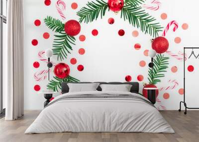 Christmas frame of fir branches and red balls decoration with confetti on white background. Festive background. Flat lay, top view Wall mural