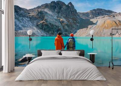 Couple of tourists looks at the lake. Honeymoon in Alps. Beautiful turquoise lake in the mountains. Wall mural