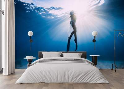 Freediver girl in bikini over sandy sea with fins. Wall mural