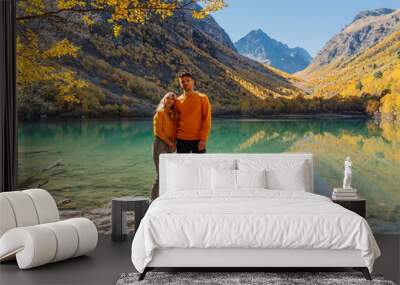 Happy couple at crystal lake in the autumnal mountains. Mountain lake and hikers couple Wall mural