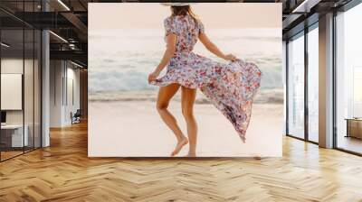 Life style woman in dress on beach at sunset or sunrise. Feminine style. Wall mural