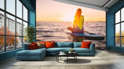 Stand up paddle boarding on a quiet sea with warm summer sunset colors. Relaxing on ocean Wall mural