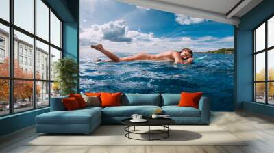 Surf girl relax on surfboard. Naked attractive woman during surfing, surfer in ocean Wall mural