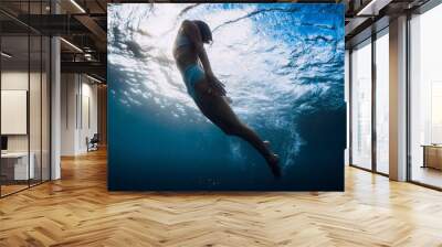 Woman underwater swim with ocean wave and sun rays. Wall mural