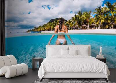 Young attractive woma posing in transparent blue ocean. Swimming in crystal water at Mauritius Wall mural