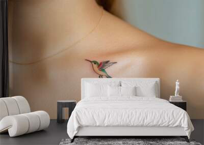 Close-up of colorful hummingbird tattoo on the collarbone, bright greens and blues, vivid motion effect, detailed featherwork, taken by camera 35mm+ lens Wall mural