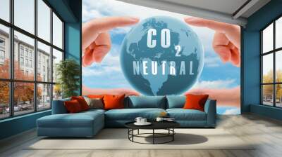 Carbon neutral concept. Hand holding CO2 neutral in globe map on blue sky and white clouds background. Environment day. Carbon neutral web banner. Environment issue. Global carbon neutrality concept. Wall mural