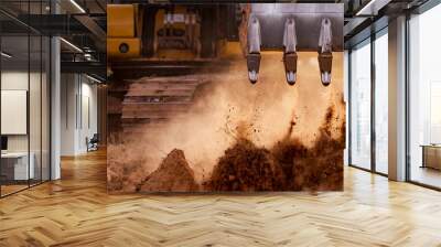 Selective focus on metal bucket teeth of backhoe digging soil. Backhoe working by digging soil at construction site. Crawler excavator digging on soil. Earth moving machine. Excavation vehicle. Wall mural