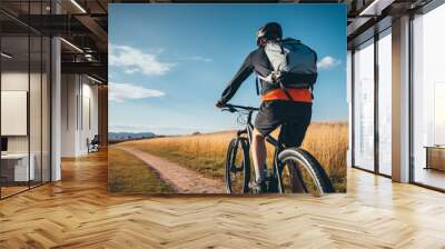 Sustainable travel. Rear view of traveler riding bicycle. Sustainable tourism and low carbon footprint. Eco-friendly journey to promote green transportation. Eco-friendly transport. Wall mural