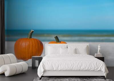 Autumn season composition. Pumpkin on the beach. Two pumpkins on sand beach shore. On background ocean water. Autumn in Florida. Fall season. Tropical nature. Wall mural