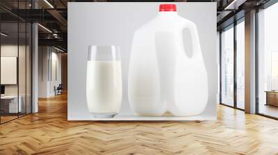 Milk. Glass of milk and one gallon of whole milk. Organic milk product. White plastic bottle one gallon or 3.78 liter on white background.  Wall mural