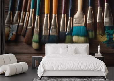 Row of artist paintbrushes closeup on artistic wooden background Brushes with colorful paints Wall mural