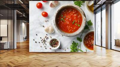 A bowl of fresh tomato sauce garnished with herbs, surrounded by cherry tomatoes, garlic, assorted peppercorns, parsley, and olive oil on a marble surface. Wall mural