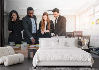 African businessman planning and discuss with Caucasian colleagues that looking on documents at an internal business group meeting. Diversity of businesspeople. Wall mural