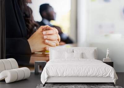 Close-up Caucasian businesswoman hands holding together on meeting table with notebook, pen and tablet with blur African businessman in the background with copy space. Legal partnership consultant. Wall mural