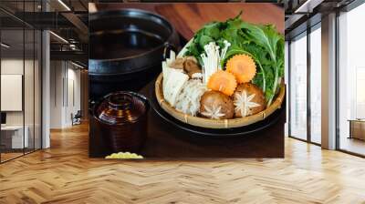 Sukiyaki vegetables set including cabbage, false pak choi, carrot, shiitake, enokitake and tofu in bamboo basket. Wall mural