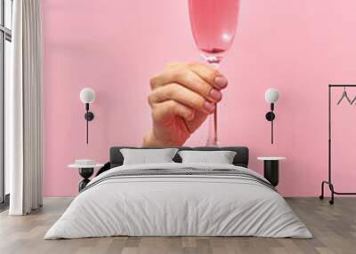 Rose wine glass in a female's hand from the hole in the wall. Wall mural