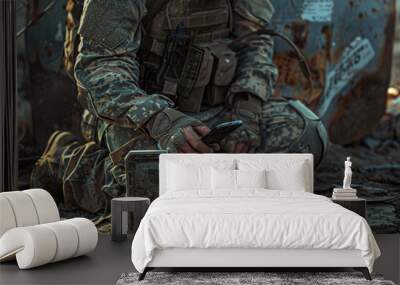 Soldier Sitting on Ground Holding Cell Phone Wall mural