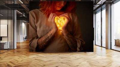 Woman holding lights in the shape of a heart Wall mural