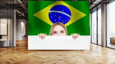 Happy cute girl with white banner against the Brazil flag backgr Wall mural