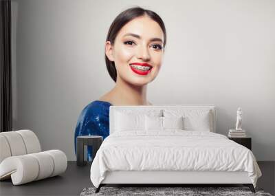 Happy girl in braces on white background. Pretty woman with braces on teeth smiling Wall mural