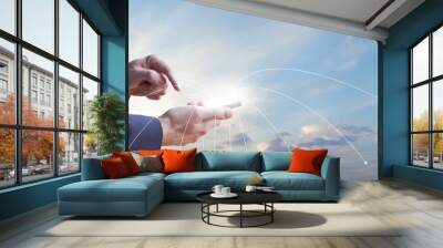 Mobile phone with white screen in hands on the backgound of blue sky, business communication Wall mural