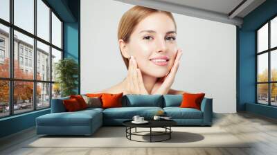 Pretty woman looking at camera. Beautiful face with healthy clear skin, natural makeup and natural eyebrows portrait on white background Wall mural