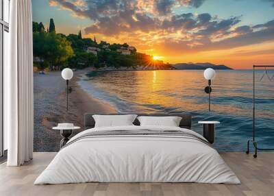 A beautiful sunset over a beach with waves crashing on the shore. Wall mural