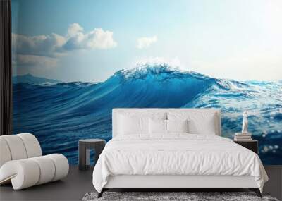 A close-up view of a wave crashing in the ocean, with a clear blue sky and bright sunlight. Wall mural