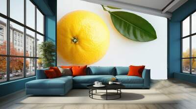 A single, ripe grapefruit with two green leaves on a white background. Wall mural