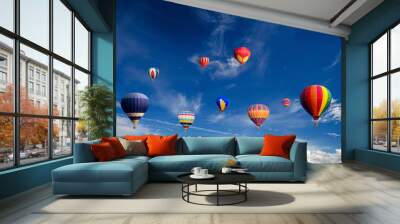 Colourful hot air balloons flying over white clouds and blue sky. Wall mural