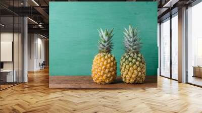 Ripe pineapples on a wooden table background. Wall mural