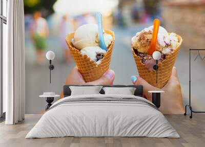 Beautiful bright ice cream with different flavors in the hands of a couple. Wall mural