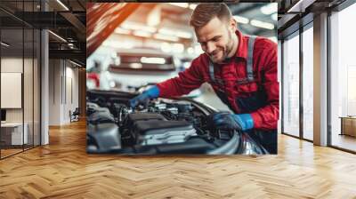 Smiling technician in red uniform inspecting vehicle motor in modern workshop Wall mural