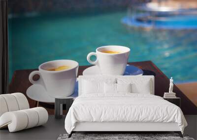 two cups of coffee on the table near the pool. Wall mural