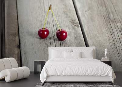 Pair of red ripe cherries on rustic weathered wooden table. Wall mural