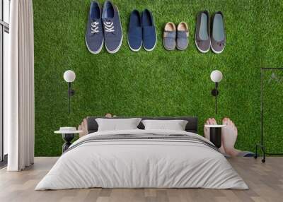 Family legs in jeans and shoes standing  on grass Wall mural