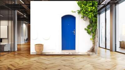 Traditional Greek blue door with white wall, plant and terra cota vase Wall mural